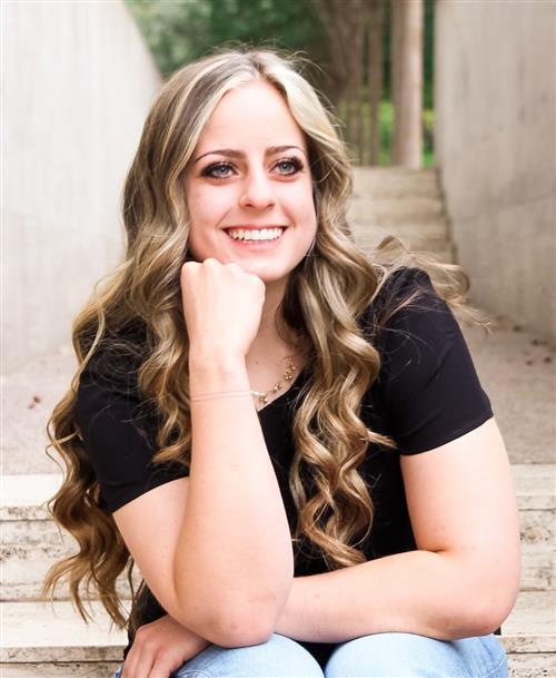Teenage girl, smiling, sitting, black shirt and jeans